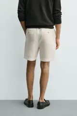 Bermuda regular fit azul marino confeccionada en lino, con bolsillos frontales, bolsillos traseros de doble vivo con botón y cierre frontal con cremallera y botón.