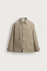 Sobrecamisa relaxed fit color beige confeccionada en tejido de algodón con estructura canvas, cuello solapa, manga larga con trabilla en los puños, bolsillos frontales de plastrón y cierre de botonadura.