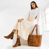 Botas tipo chelsea de cuero vacuno negro, con elásticos laterales, taco cuadrado y punta fina.