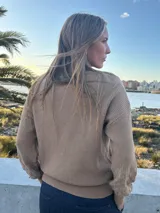 Sweater de punto liviano color camel con escote en V y diseño texturizado en rombos en las mangas y el ruedo.