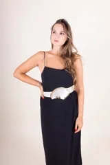 Cinturón de cuero color tostado con hebilla grande irregular de nácar con borde dorado.