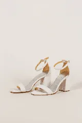 Sandalias de taco cuadrado y altura media, con tira delantera simple y tira ajustable al tobillo mediante hebilla metálica.