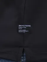 Chomba de piqué negra, de corte clásico, con cuello polo y tapeta de dos botones.