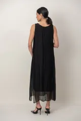 Vestido midi de gasa negro, con solera sin mangas, escote fruncido y detalle de aplique floral en el hombro.