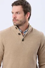 Buzo tejido texturado color verde oscuro, con cuello alto y cierre parcial de tres botones. Tiene mangas largas y un pequeño detalle de etiqueta marrón en el dobladillo inferior.