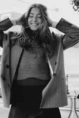 Blazer oversize de corte recto con cuello solapa, manga larga con hombreras y cierre frontal cruzado con botones. Presenta diseño de raya diplomática, bolsillos delanteros y forro interior.