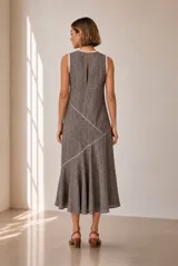 Vestido midi sin mangas de color marrón con sutiles costuras decorativas diagonales en contraste y terminación evasé.