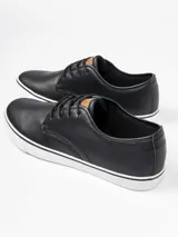 Zapatilla de estilo casual con capellada de cuero sintético negro, cordones al tono y suela de goma blanca con detalle de línea negra.