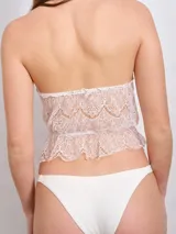 Top de lencería color crema, confeccionado en encaje floral, con cuello halter y corte ajustado.