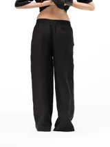 Pantalón de lino de corte holgado y tiro ajustable, con cintura elástica y cordón. Presenta bolsillos laterales y un bolsillo trasero.