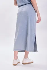 Falda midi celeste con efecto lavado, corte recto y abertura lateral.