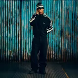 Campera de tejido de punto color negro con cierre frontal completo. Presenta rayas laterales en color gris en ambas mangas y el logo de la marca bordado en el pecho.