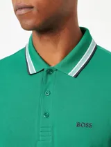 Remera polo de algodón color gris oscuro, marca Boss, modelo Paddy. Corte regular fit, cuello y puños con ribete doble en blanco y gris. Logo bordado en el pecho.