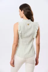 Musculosa de lino rayada con cuello mao y volados en los hombros. Presenta diseño de rayas verticales y aplique de etiqueta con logo en la parte posterior.