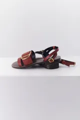 Sandalias planas con estampado animal, hebilla dorada y suela marrón.