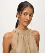 Blusa halter sin mangas confeccionada en mezcla de algodón, viscosa y lino, con cuello redondo fruncido y diseño fluido.