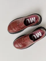 Mocasines color marrón con estampado de cocodrilo y plataforma negra con suela dentada.