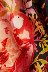 Vestido túnica con estampado floral en tonos rosados y negros, de tejido arrugado, silueta oversized, mangas largas con gran volumen y cuello redondo con abertura de cerradura y botón oculto en la nuca. Largo hasta la rodilla.