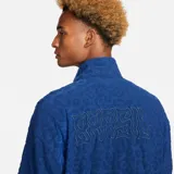 Campera deportiva Nike de la selección de Brasil, color azul con diseño texturizado en relieve tipo animal print. Cuenta con cuello alto, cierre frontal completo, bolsillos laterales y detalles en verde flúor como el logo de Nike y el escudo de la CBF en el pecho.