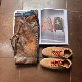 Pantalón de corte recto que combina denim azul en la parte superior y laterales con cuero marrón de efecto gastado en el frente.