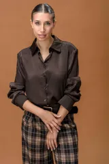 Body tipo camisa de seda color marrón chocolate, con cuello clásico, cierre frontal de botones y mangas largas con puños. El diseño permite un ajuste ceñido al cuerpo.