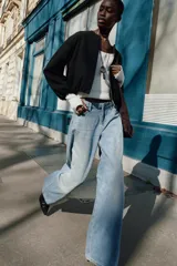 Chaqueta bomber de cuello redondo y manga larga con diseño holgado. Presenta cierre frontal con cremallera, bolsillos delanteros de vivo y acabados elásticos en los puños y el ruedo.