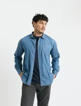 Camisa de denim de algodón con cuello clásico, cierre frontal con botones, bolsillo superior de parche y mangas largas con puños abotonados.