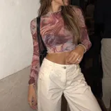 Top de microtul manga larga con estampado abstracto en tonos marrón y azul, cuello alto y terminaciones con dobladillo ondulado.