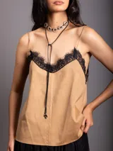 Top de breteles finos confeccionado en material símil gamuza color beige, con detalle de encaje negro en el escote y costura vertical frontal.