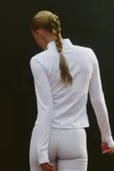 Campera deportiva de mujer en tejido funcional color blanco, corte ajustado, cuello elevado, cierre frontal y mangas largas con abertura para el pulgar.