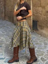 Pollera midi de diseño asimétrico con caída fluida y terminación en puntas. Presenta un estampado cuadrillé en tonos verde oliva, mostaza y beige, con cintura alta y calce cómodo.