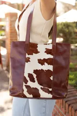 Bolso tote de cuero marrón con panel central de cuero con estampado animal print de vaca.