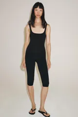 Pantalón capri negro de tiro medio y cintura elástica, confeccionado en hilatura con poliamida.