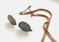 Correa de cuero marrón con textura de escamas, con terminales de cuero con broches metálicos para sujetar a las patillas de los lentes.