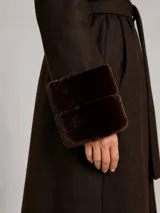 Tapado largo color chocolate con diseño envolvente, cuello amplio y puños con detalle de piel sintética. Incluye cinturón desmontable para ajustar a la cintura y bolsillos laterales.