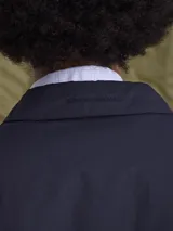 Sobretodo de corte recto y diseño minimalista en color azul marino, con cierre frontal de botones y cuello camisero.