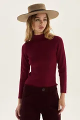 Polera de tejido de punto acanalado en color beige, con cuello alto y mangas largas. Presenta un sutil acabado brillante gracias a sus detalles en lurex.