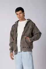 Campera oversize con cierre frontal, capucha y acabado acid wash. Presenta costuras verticales decorativas y puños de tejido acanalado.