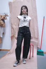 Pantalón negro de corte recto con costuras blancas contrastantes y detalle de cordones cruzados en la cintura.