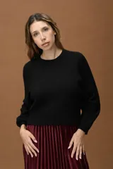 Sweater básico de diseño corto, con cuello redondo y manga larga. Presenta un calce cómodo y minimalista, ideal para combinar con diversas prendas.