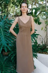 Vestido midi marrón de punto con escote en V y tirantes finos, con detalle de costuras verticales en el talle y falda acampanada.