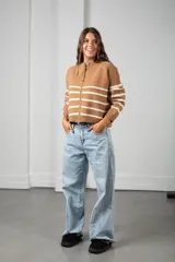 Saco de punto beige con rayas horizontales blancas, cierre frontal completo y cuello redondo.