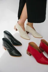 Botines de cuero color beige con diseño de tajo frontal, punta fina y taco cuadrado de madera.