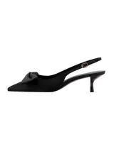 Zapato de tacón tipo slingback en color negro, con diseño destalonado, puntera fina y un detalle de lazo en la parte delantera. Cuenta con tira ajustable en el talón con hebilla metálica dorada y taco fino de altura baja.