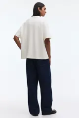 Remera de corte holgado confeccionada en punto interlock de algodón, con cuello redondo acanalado, hombros caídos y bajo recto.