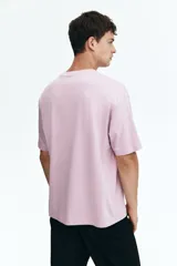 Remera de punto de algodón de peso medio en color lila, con cuello redondo ribeteado, hombros caídos y bajo recto. Diseño de corte relajado y silueta casual.
