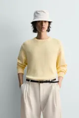 Jersey de punto color amarillo pálido, de corte relajado (relaxed fit), con cuello redondo y manga larga. Presenta acabados en rib en puños y bajo.