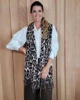 Bufanda larga de tejido suave con estampado animal print de leopardo y terminaciones con flecos en los extremos.