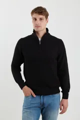 Sweater verde de punto inglés con cuello alto y cierre metálico frontal. Tiene mangas largas y terminaciones en punto canalé.