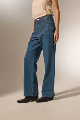 Pantalón jean azul de calce recto y tiro alto, con bolsillos y apliques de strass.